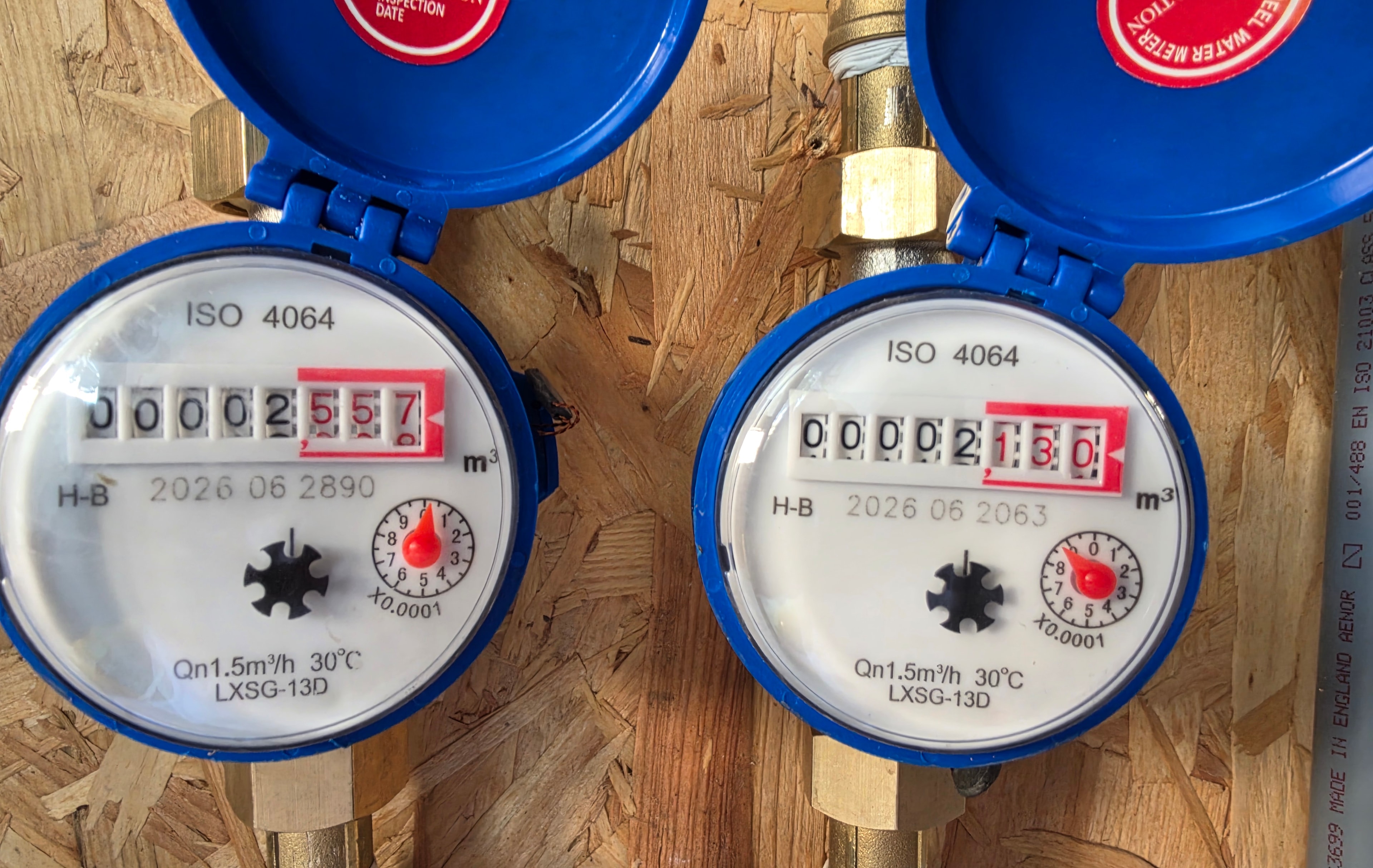 Two ISO 4064 water meters side by side — left meter without W&G reads higher, right meter with W&G Air Block installed reads lower